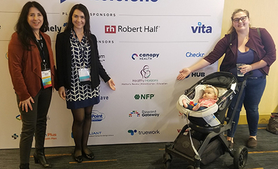 Cassi Janakos, a baby in a stroller, and another person at a convention